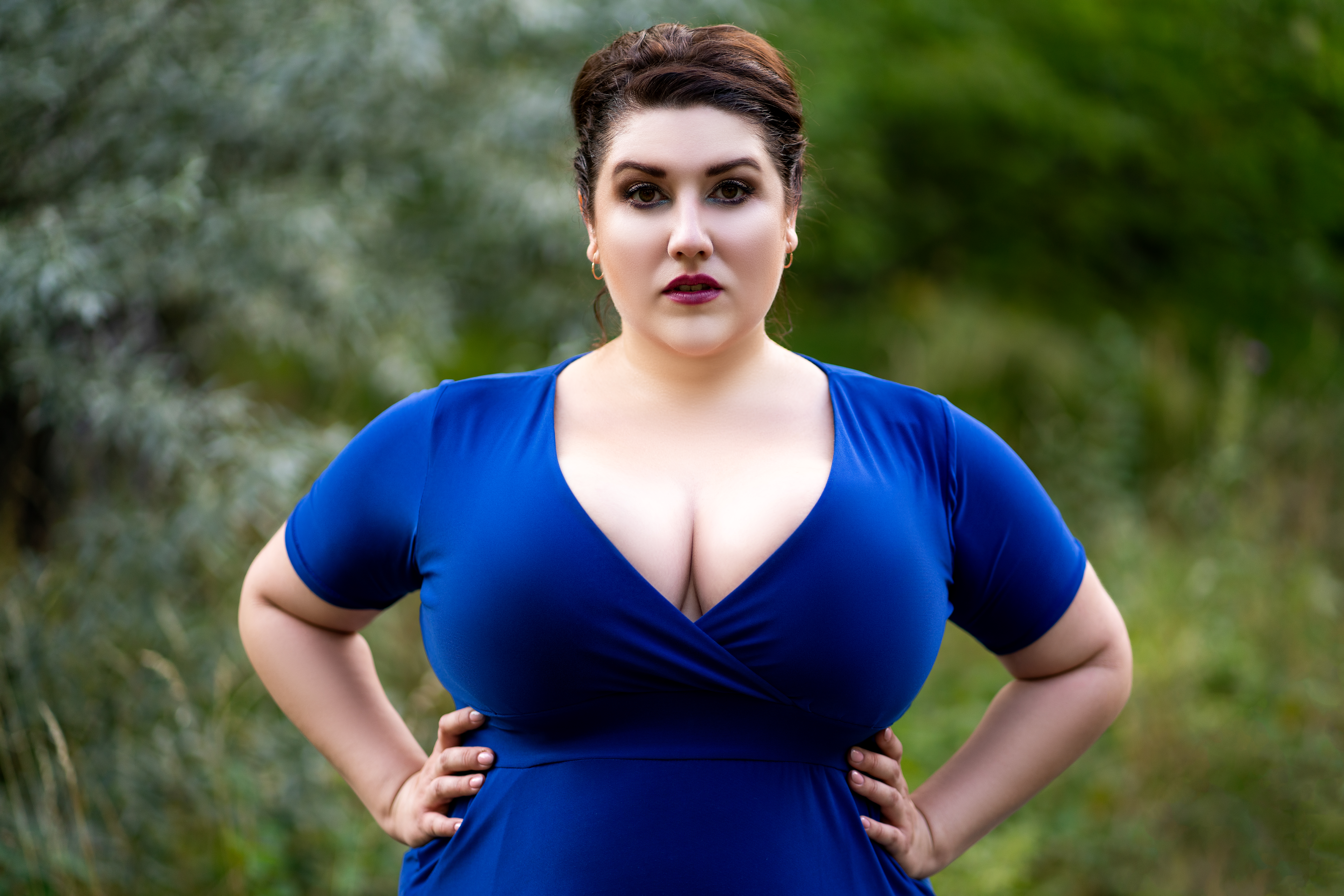 breast reduction candidate woman in a blue shirt with a brunette pixie cut