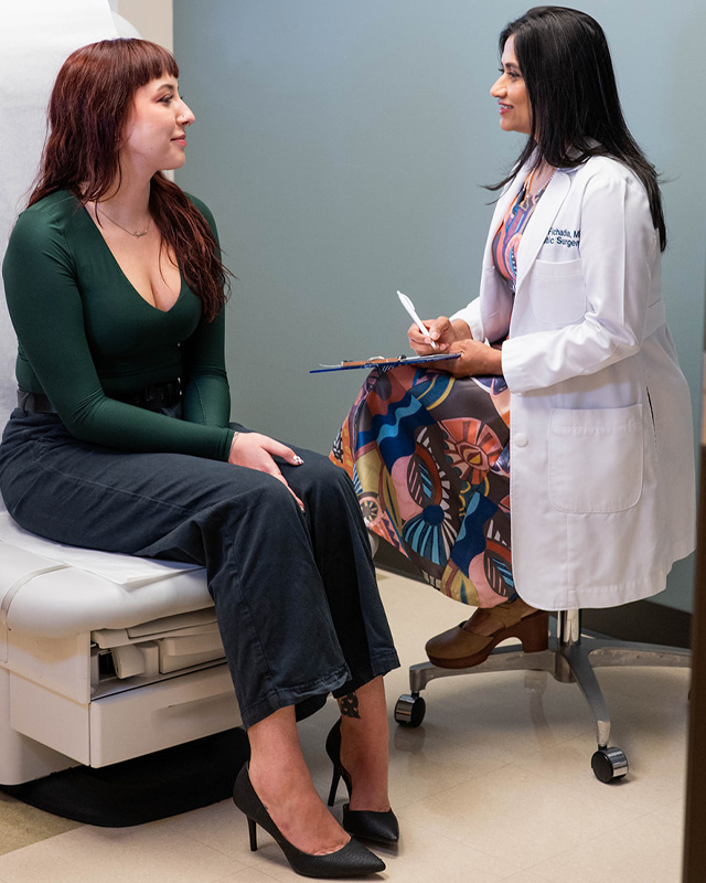 Dr. Hetal Fichadia explaining breast augmentation with fat transfer surgery plans to a female patient